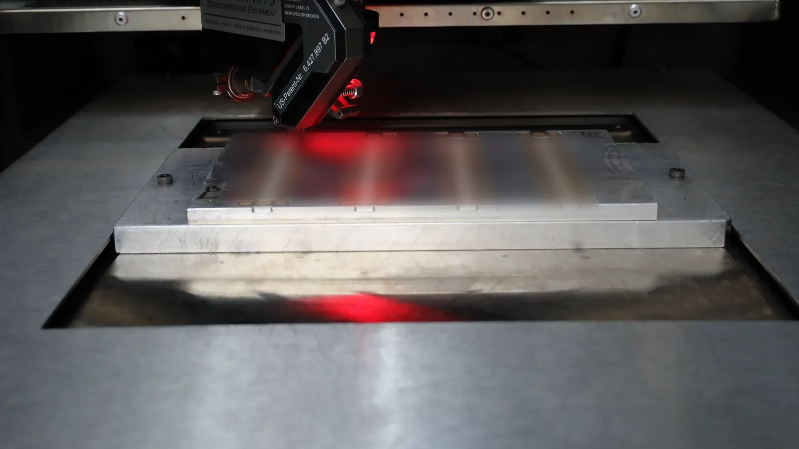 Red-lit bonder running a panel of coupons